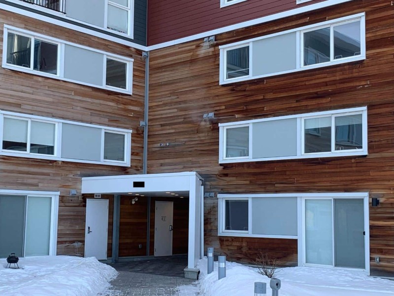 The front entrance of an apartment building in winter.
