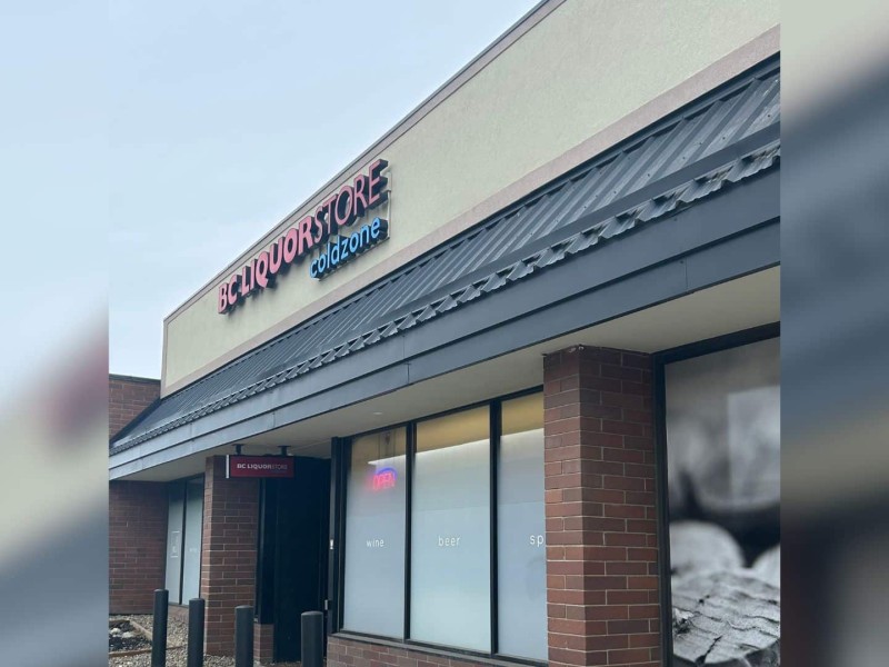 The front of the BC Liquor Store in Fort St. John. A brick building with an open sign in the window.