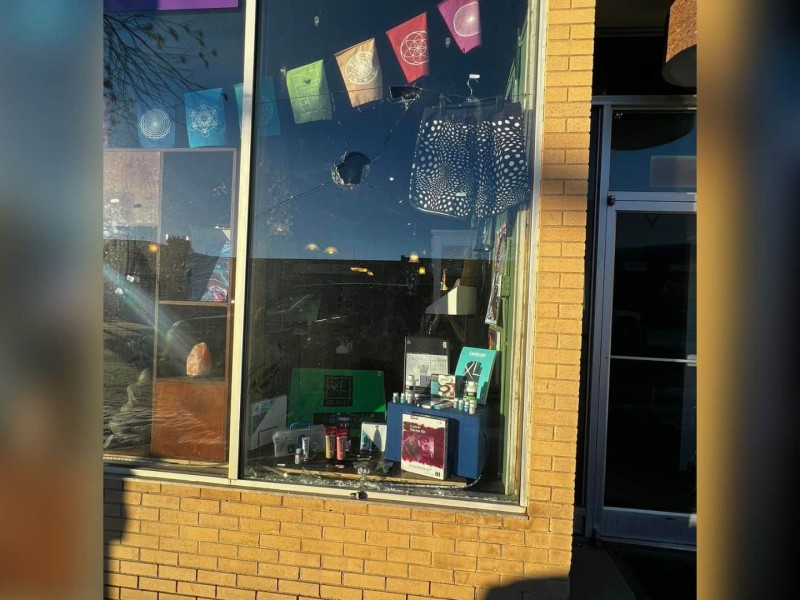 A small shop-front with a large hole in the front window.