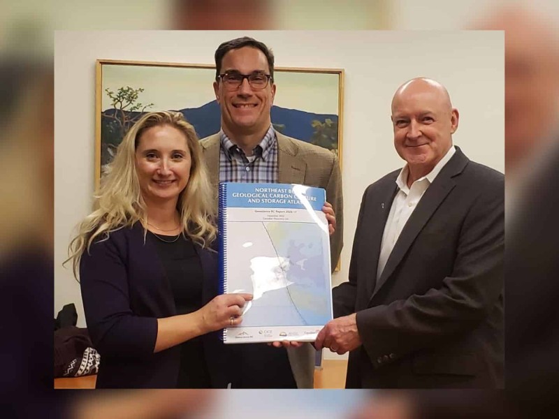 A woman and two men hold the completed study. The woman is blonde. One of the men is bald