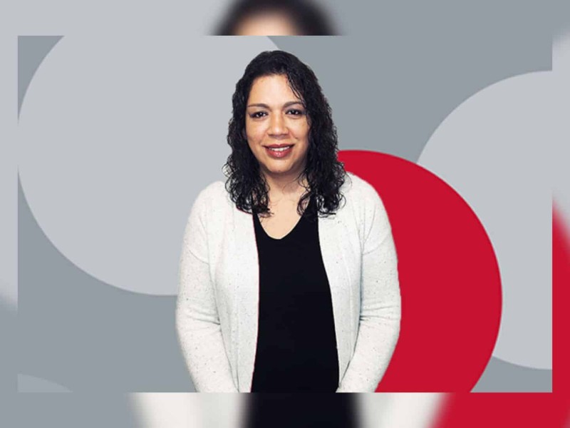 Moberly Lake resident Carrie Paquette stands in front of a grey and red background after winning over $960 thousand dollars on PlayNow.com.