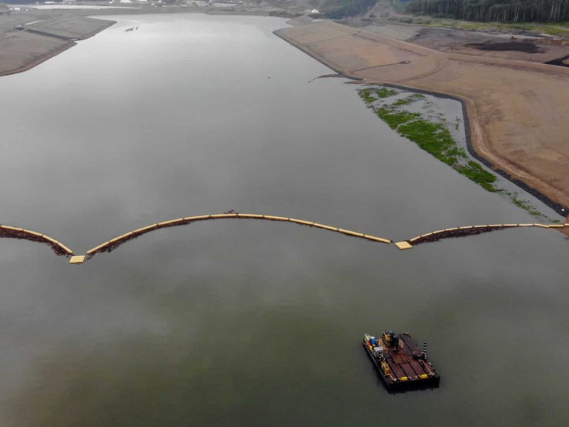 The headpond at Site C. A large body of water with sandy banks and a boat in it.