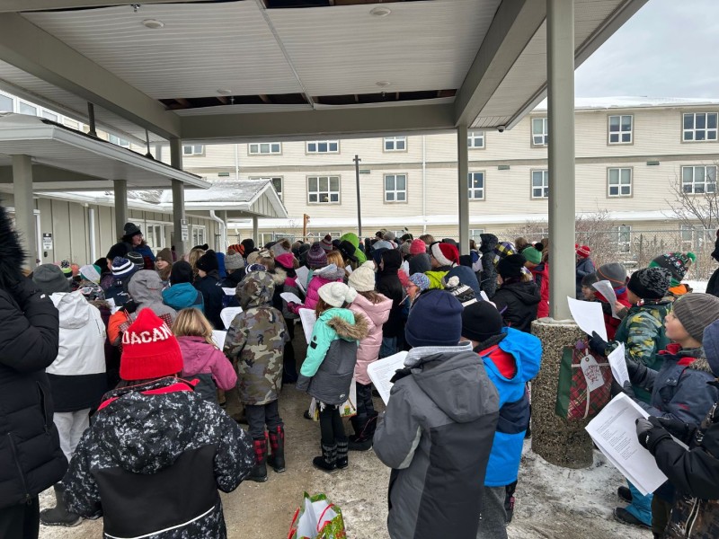 Group of students singing outside of Heritage Manor (Shailynn Foster)
