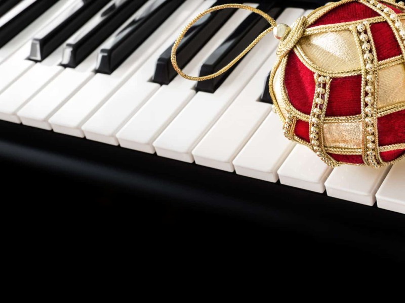 A Christmas ornament sitting on a piano.