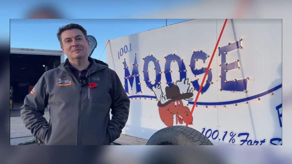 Adam Reaburn standing in front of the Light a Moose sign. (Jordan Prentice)