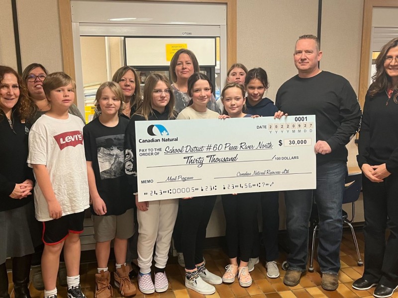 Chris Willson of CNRL presents cheque to students and District #60 members.