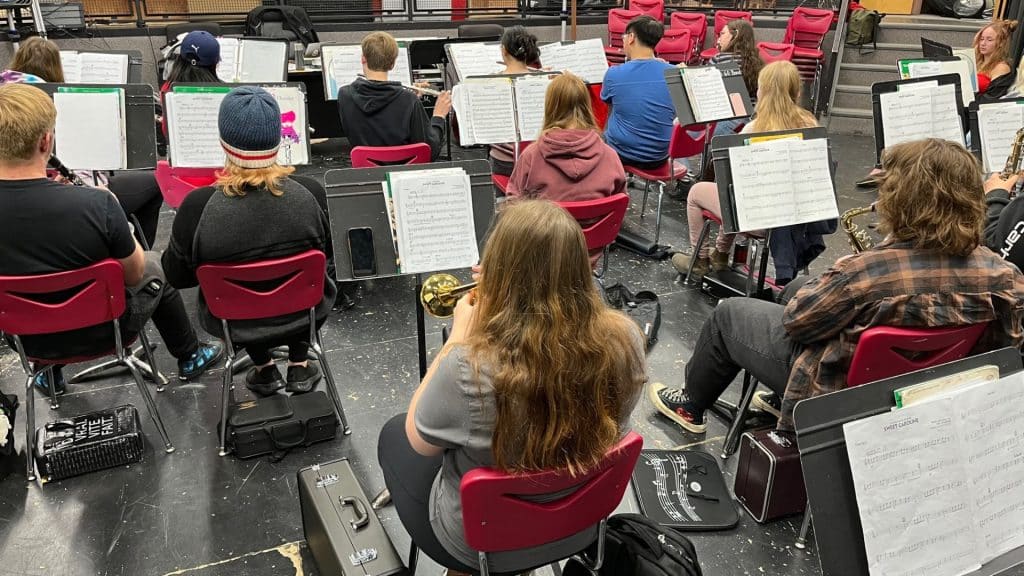 Band students practicing with their music sheets in front of them.