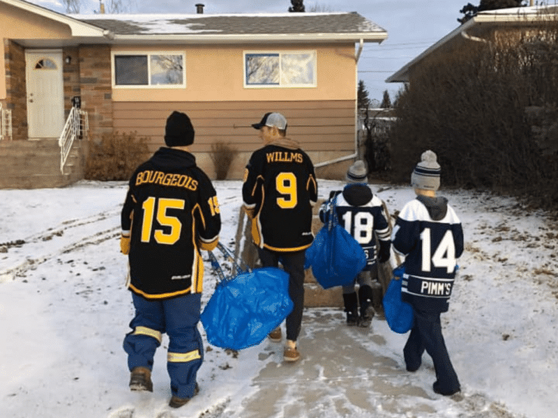 Huskies and minor hockey players going door to door to 'Fill the Bus' for the food bank.