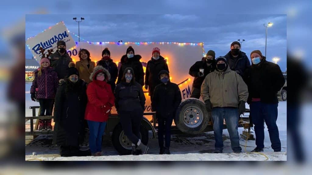Moose FM staff in front of Light a Moose Sign (Adam Reaburn)