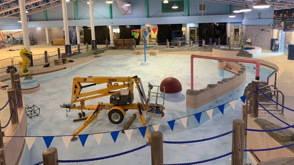 Empty pool with work vehicles inside.