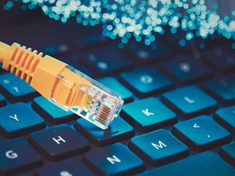 An internet cable on a keyboard (Canva)