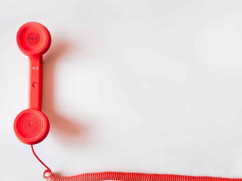 A red corded phone. (Canva)