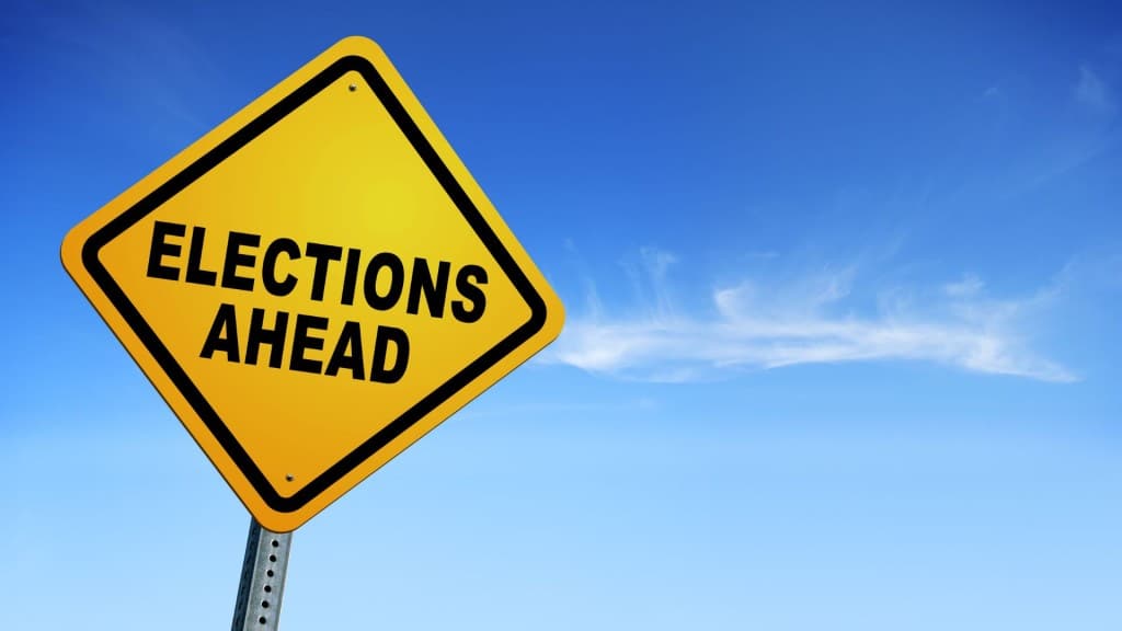 A yellow street sign that says "Elections Ahead."