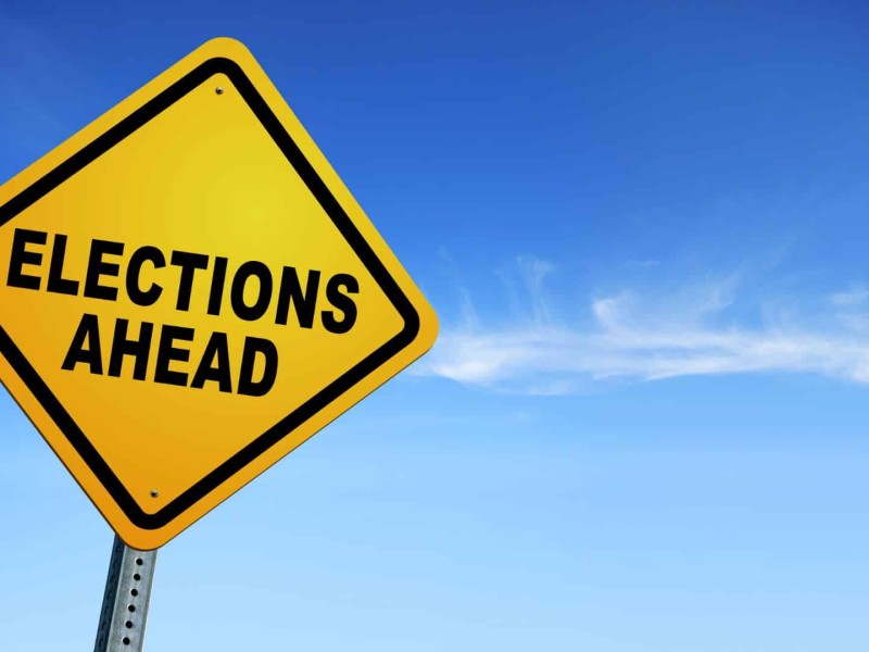 A yellow street sign that says "Elections Ahead."