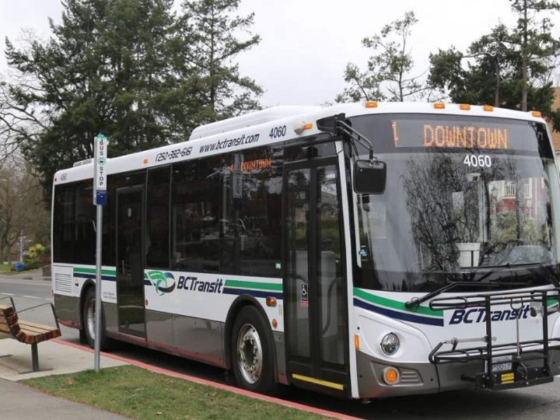 A white BC Transit bus with green and blue waves on it.