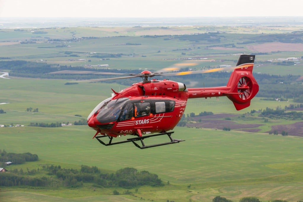 A bright red helicopter in flight.