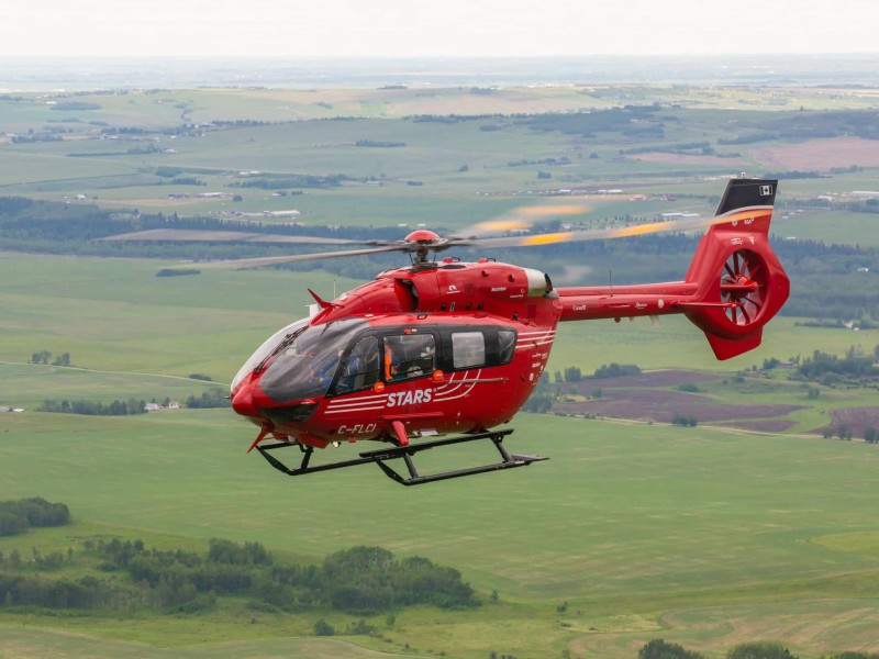 A bright red helicopter in flight.