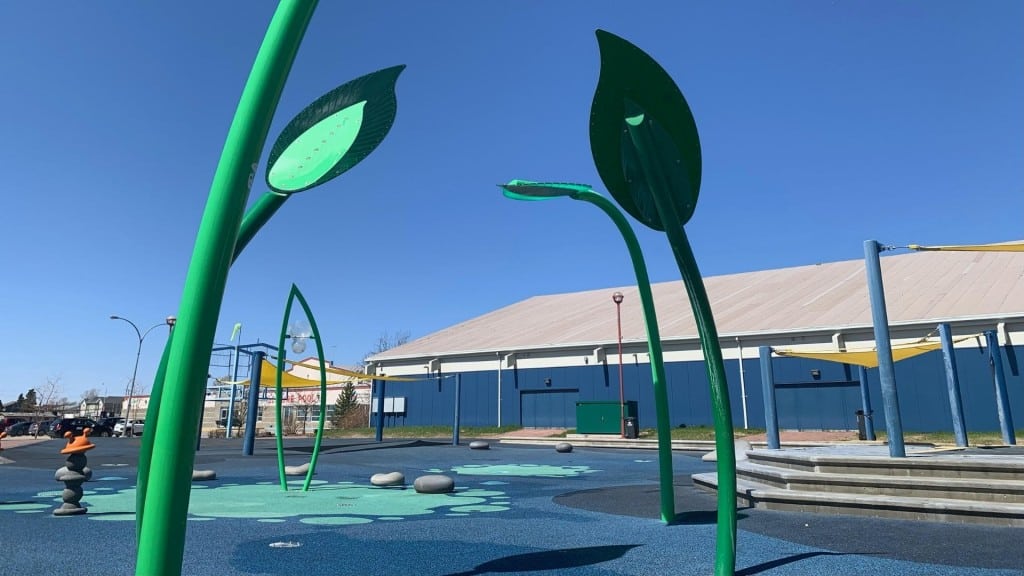 A picture of a green spray park.