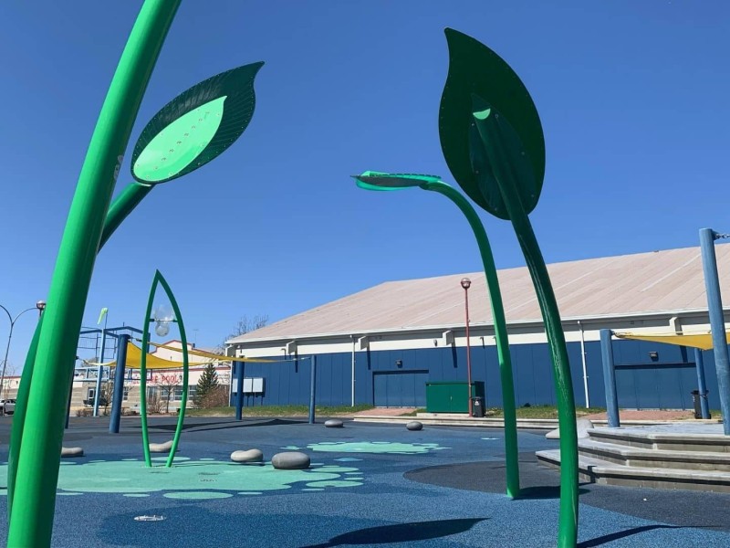 A picture of a green spray park.