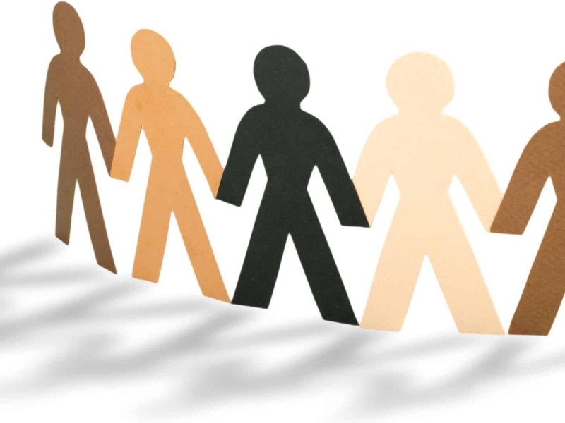 Paper dolls of different colours on a white background.