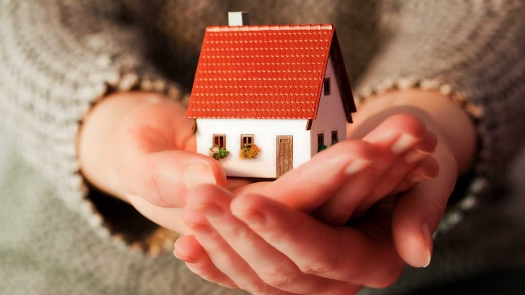 A little house being held in someone's hands.