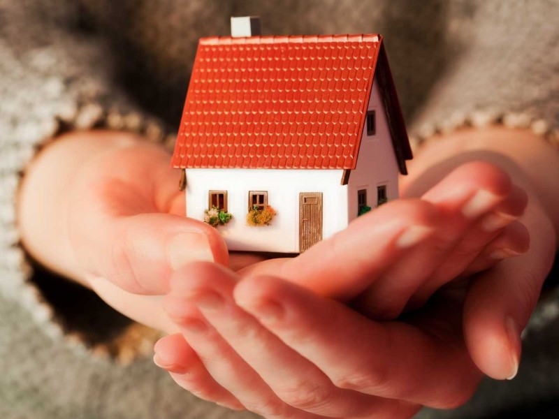 A little house being held in someone's hands.