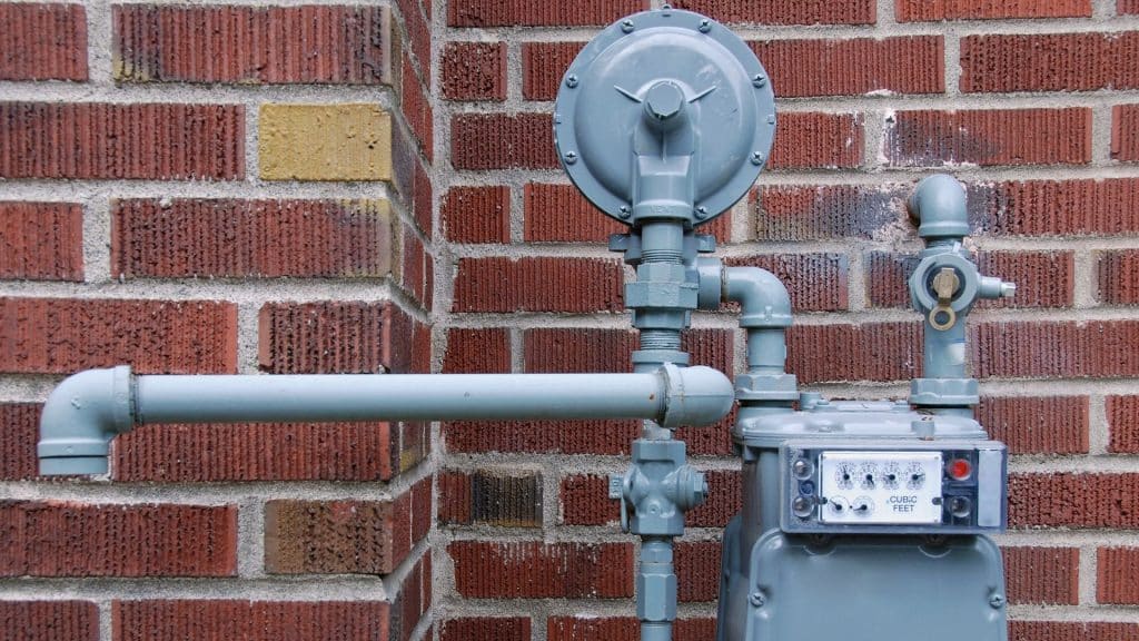 A picture of a grey gas meter on a brick building.