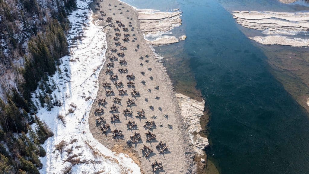 A section of river with a sandy bank on one side. There are scattered pieces of constructed terrain along the sand.