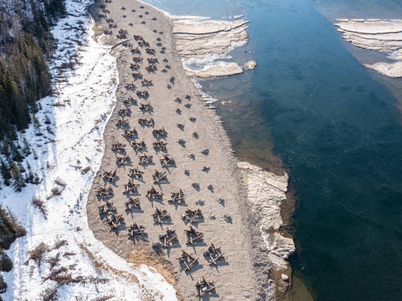 A section of river with a sandy bank on one side. There are scattered pieces of constructed terrain along the sand.