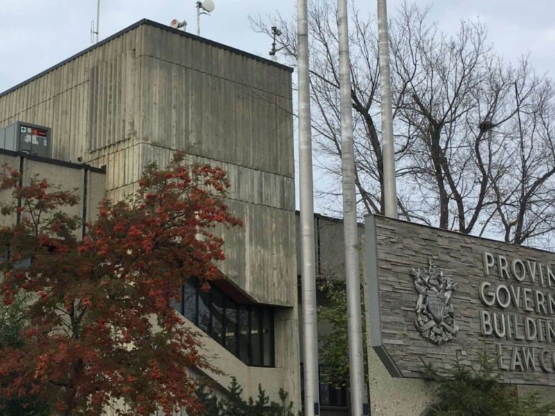 The Provincial Government Building and Law Courts sign in front of the grey brick building.