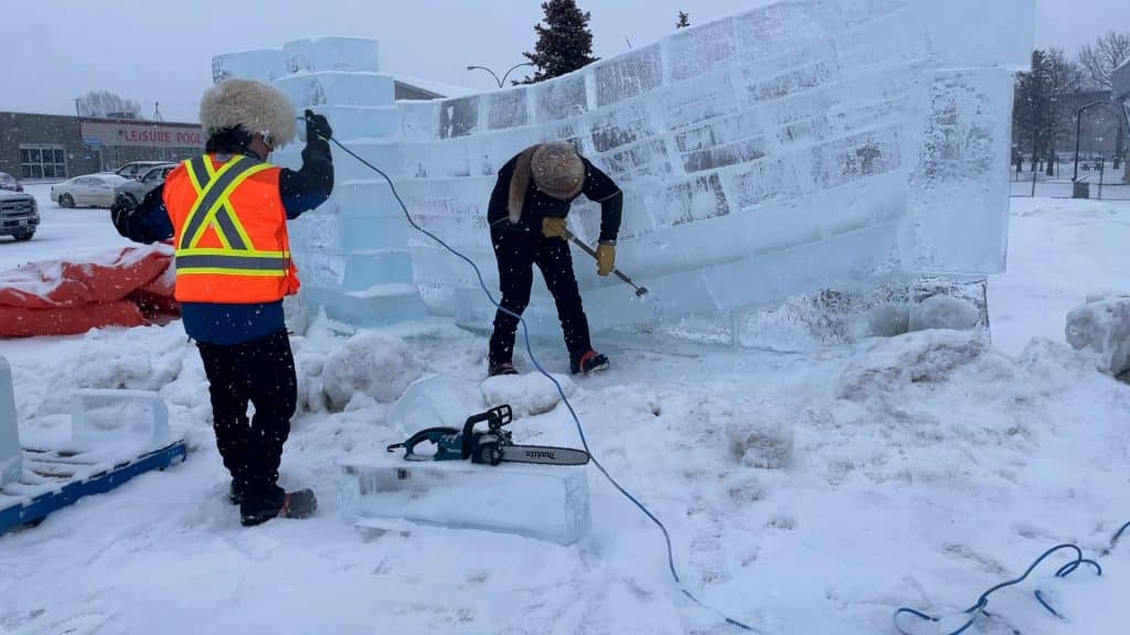 Two men working on an ice sculpture at the High On Ice festival in Fort St. John.