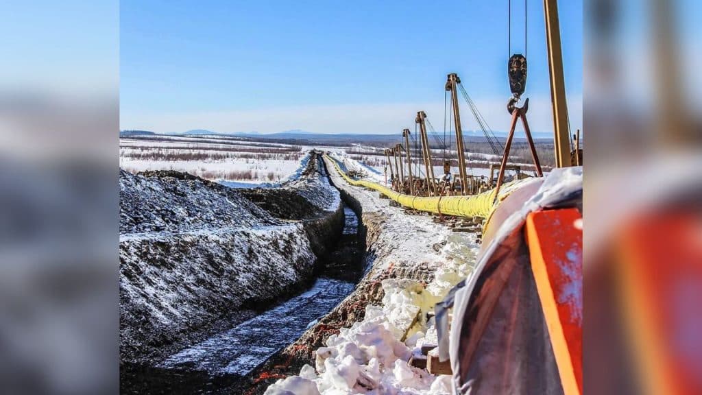 A pipeline being constructed in a snow field. 