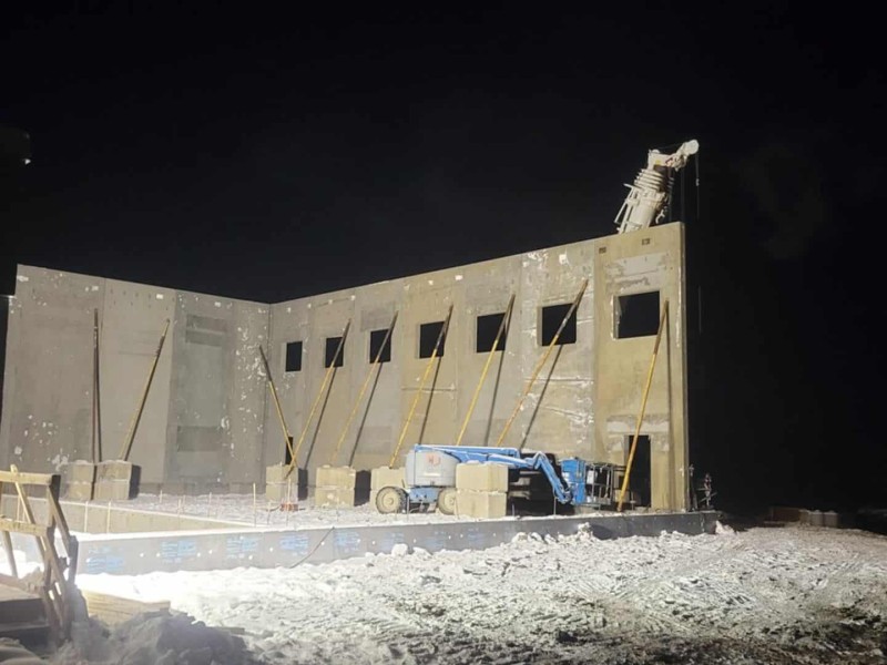 A night time photo of a construction site putting walls up