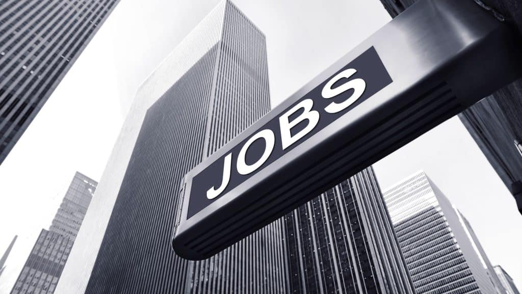 A grey cityscape with a sign that reads 'JOBS'