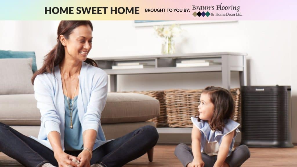 Adult sitting crossed-legged smiling next to child sitting crossed-legged