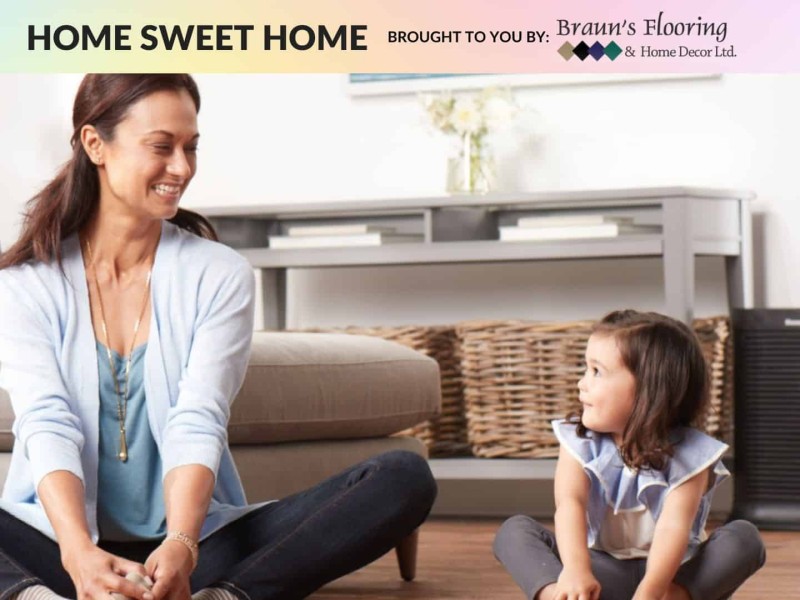 Adult sitting crossed-legged smiling next to child sitting crossed-legged