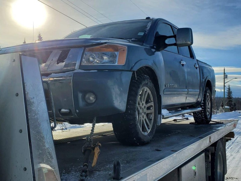 A black truck getting ready to be towed.