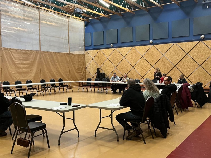 A gymnasium where tables are set up in a square. Chairs along the outside
