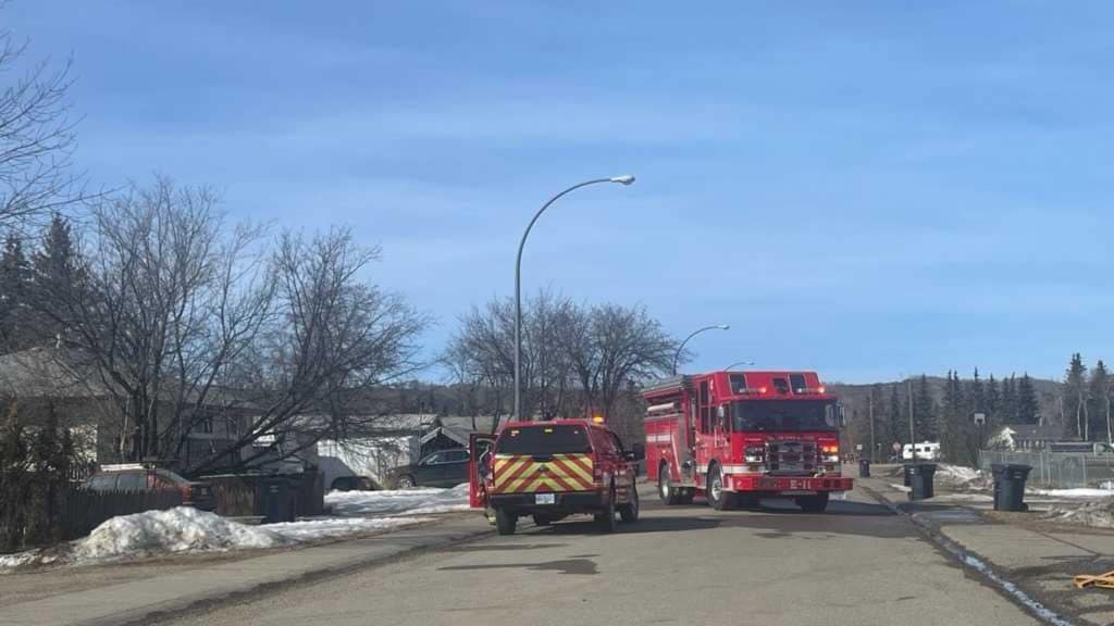 A neighborhood street with a fire truck in the road.