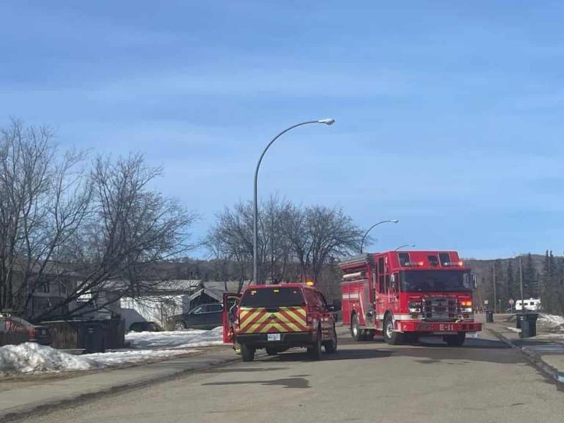 A neighborhood street with a fire truck in the road.