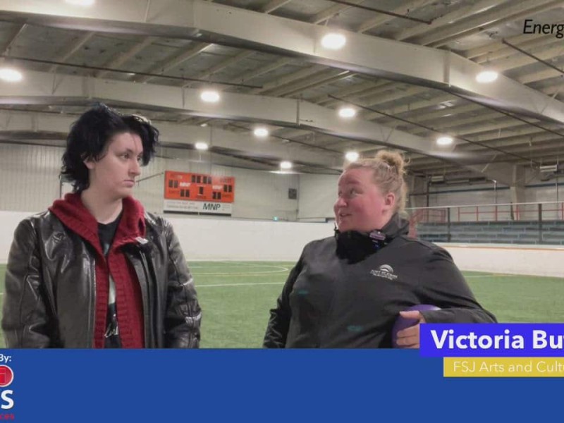 Two people standing in an indoor soccer arena