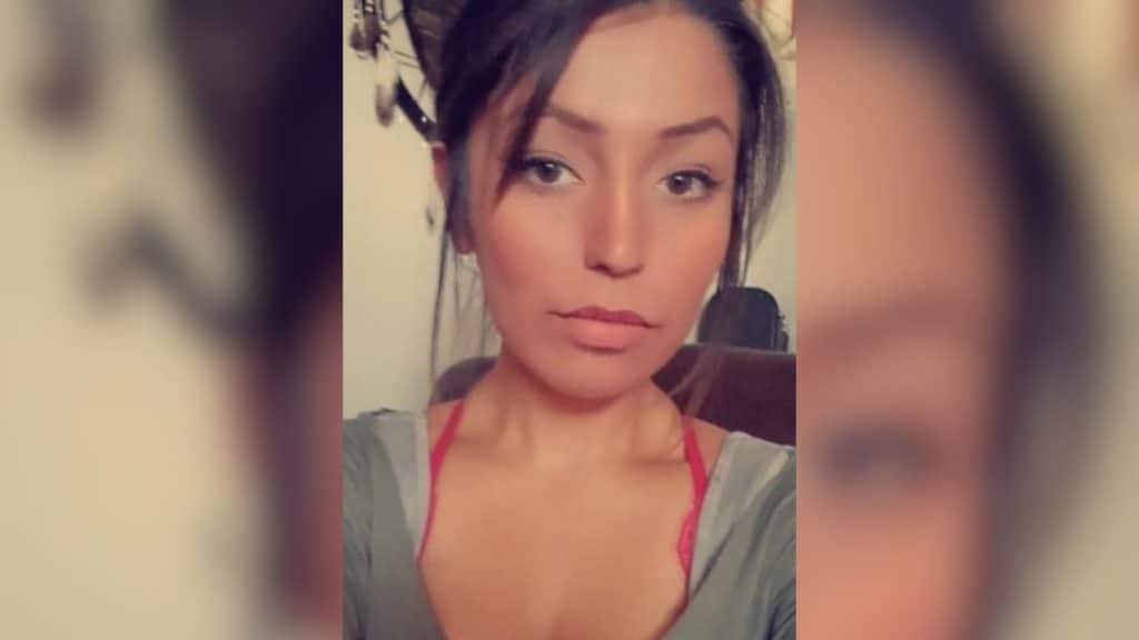 A picture of a dark haired woman wearing a grey shirt.