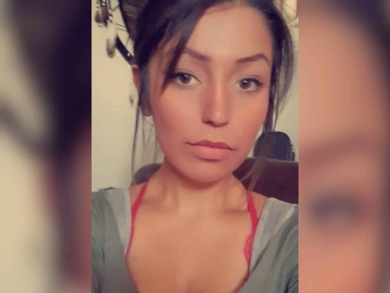 A picture of a dark haired woman wearing a grey shirt.