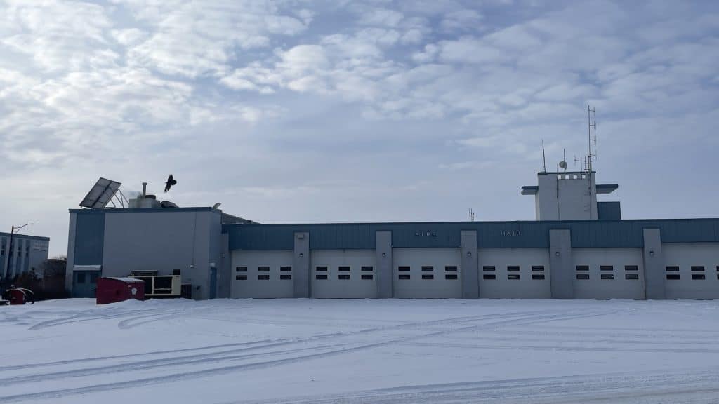 A large blue building with white garage doors.