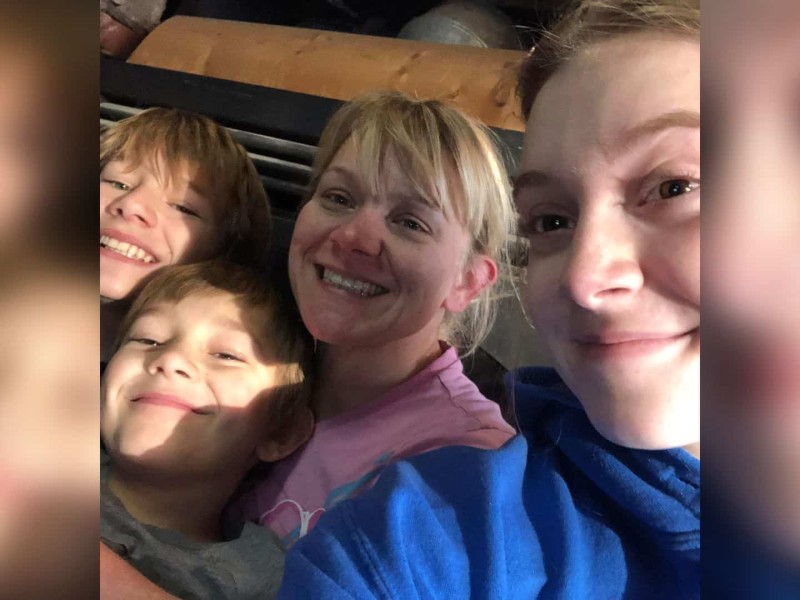 A blonde mom and her two boys to her right and her daughter on her left.