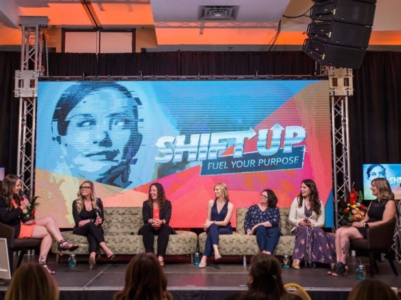 A group of women on couches talking on stage.