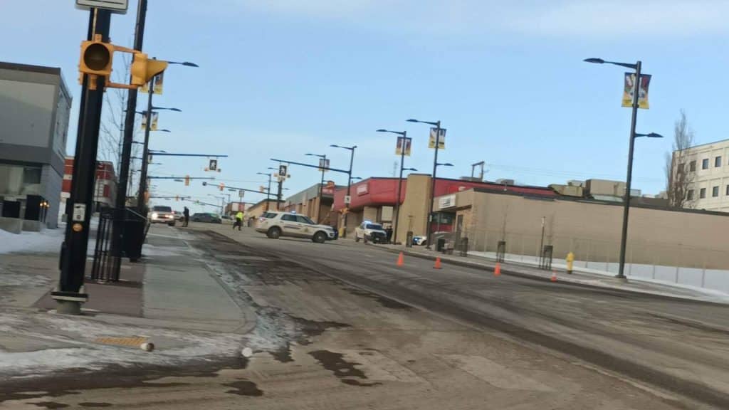 A shot of police on a road in Fort St. John with pylons blocking off most of the road.