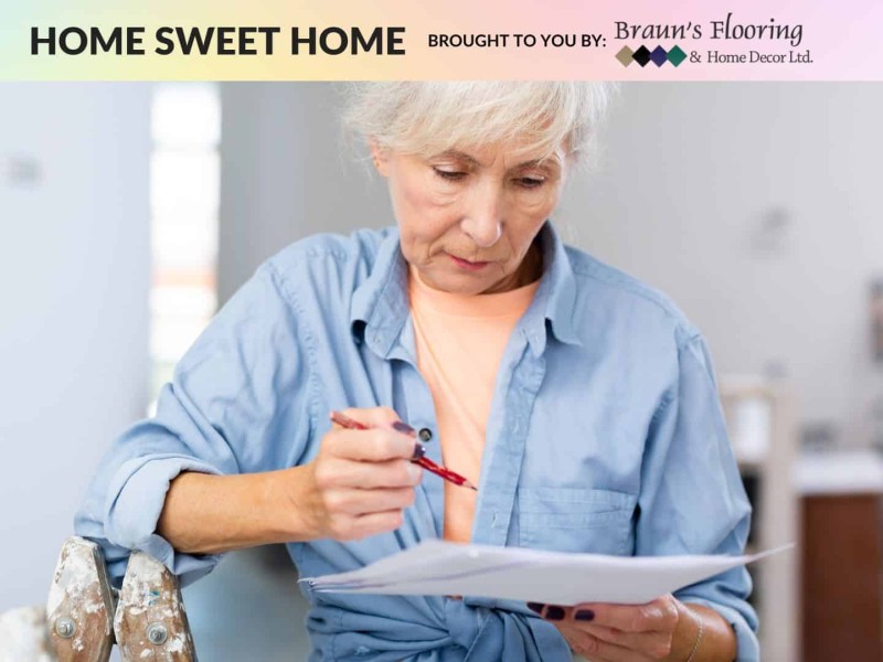 Person with white hair and a blue shirt looking at a piece of paper