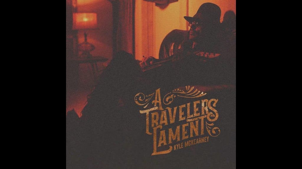 A grainy filtered photo of a man in a hat and sunglasses leaning back in a chair holding a guitar. The words "A Travelers Lament Kyle McKearney" are also in the photo.