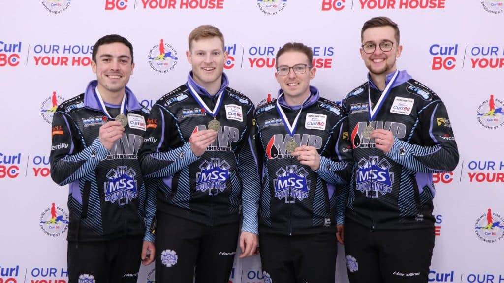A team of four curlers holding their first place medals at the BC Championships.